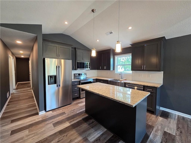 540 N Lexington St, Adrian, MO 64720 - kitchen with stainless steel appliances, a sink, vaulted ceiling, wood finished floors, and a kitchen island