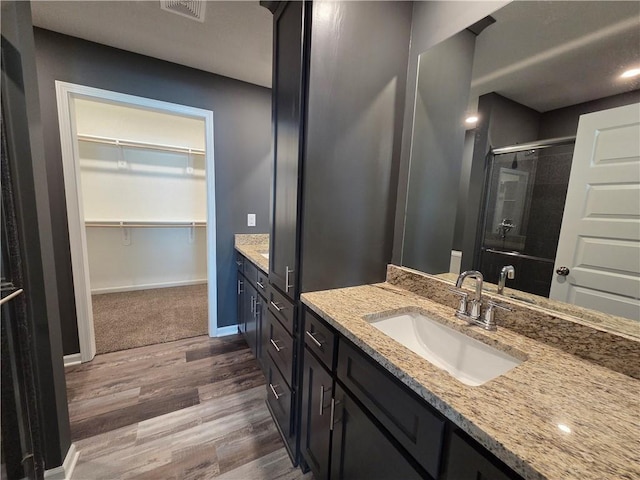 540 N Lexington St, Adrian, MO 64720 - full bath with wood finished floors, a shower stall, vanity, and a spacious closet