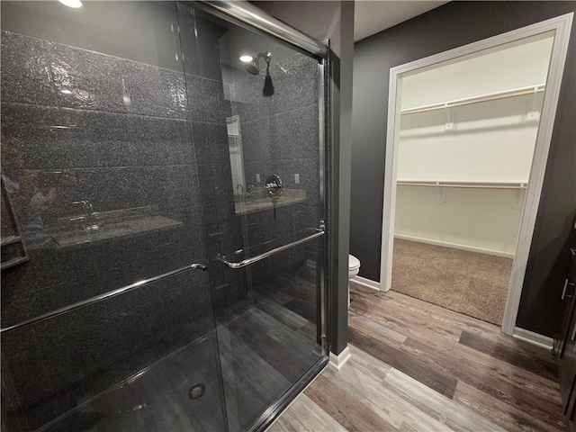 540 N Lexington St, Adrian, MO 64720 - full bath with a shower stall, toilet, wood finished floors, a walk in closet, and baseboards