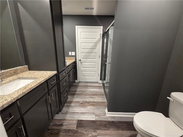 540 N Lexington St, Adrian, MO 64720 - bathroom with wood finished floors, vanity, a stall shower, and toilet