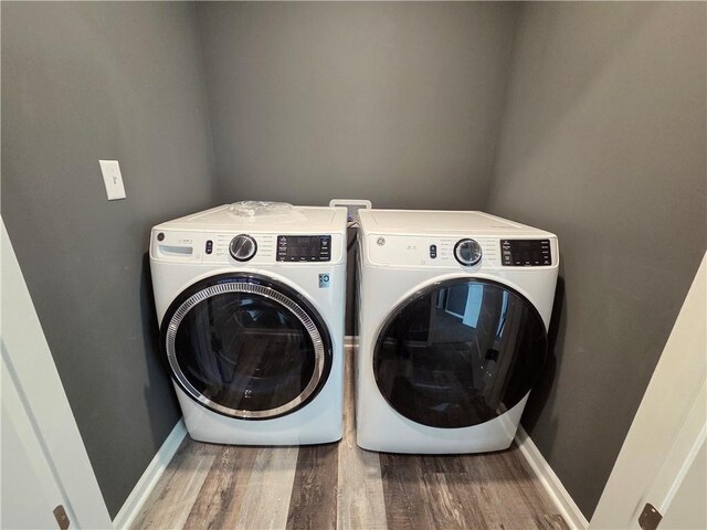 540 N Lexington St, Adrian, MO 64720 - laundry room featuring washing machine and clothes dryer, wood finished floors, and baseboards