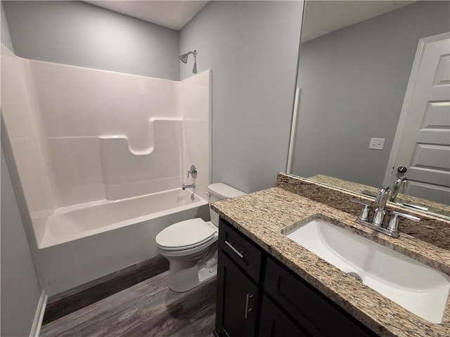 540 N Lexington St, Adrian, MO 64720 - bathroom with wood finished floors, toilet, vanity, and shower / washtub combination