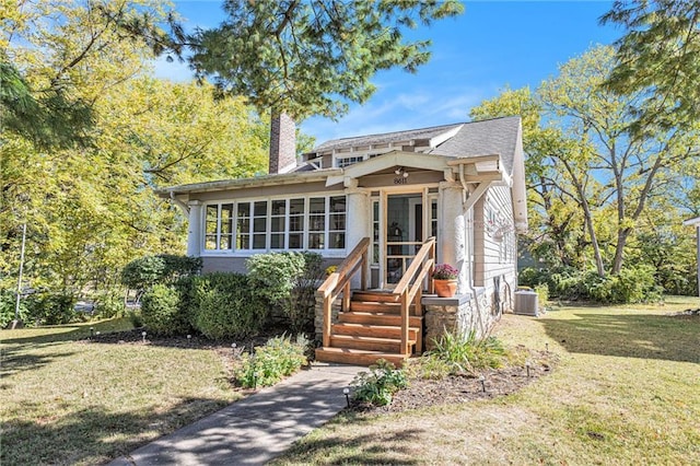 view of front of property with a chimney, a front lawn, and central AC unit