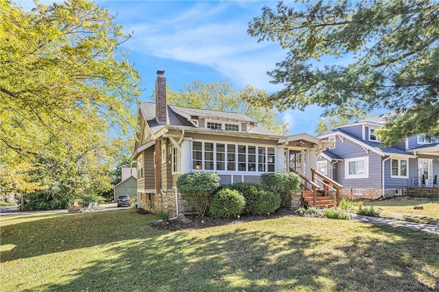 view of front facade featuring stone siding, a chimney, and a front yard