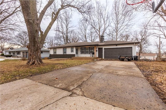 ranch-style home with driveway, a chimney, and an attached garage