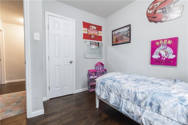 bedroom featuring baseboards and dark wood-type flooring