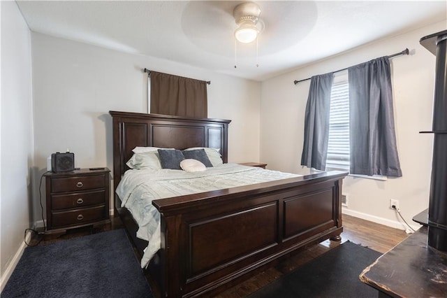 bedroom featuring dark wood finished floors, baseboards, and ceiling fan