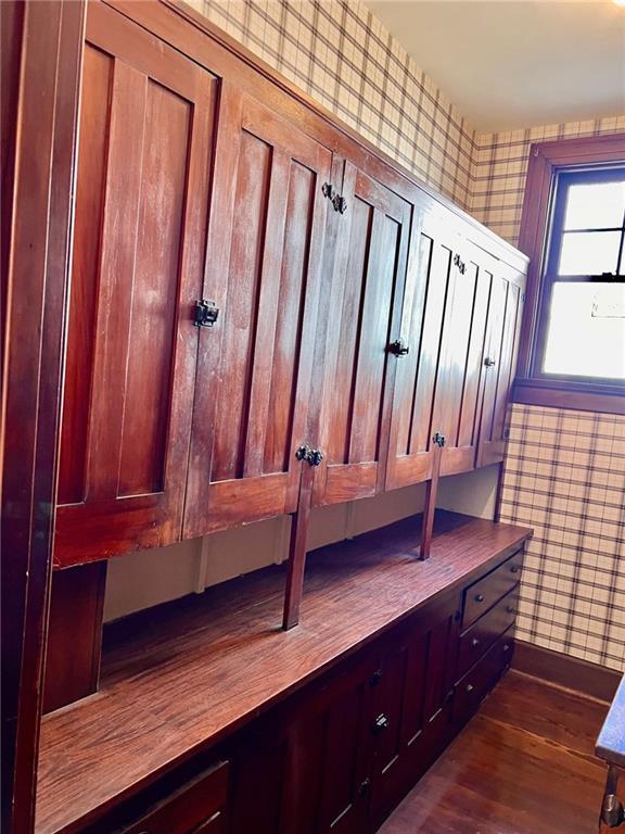 mudroom featuring baseboards, dark wood-style flooring, and wallpapered walls