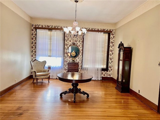 sitting room with a chandelier, wood finished floors, and baseboards