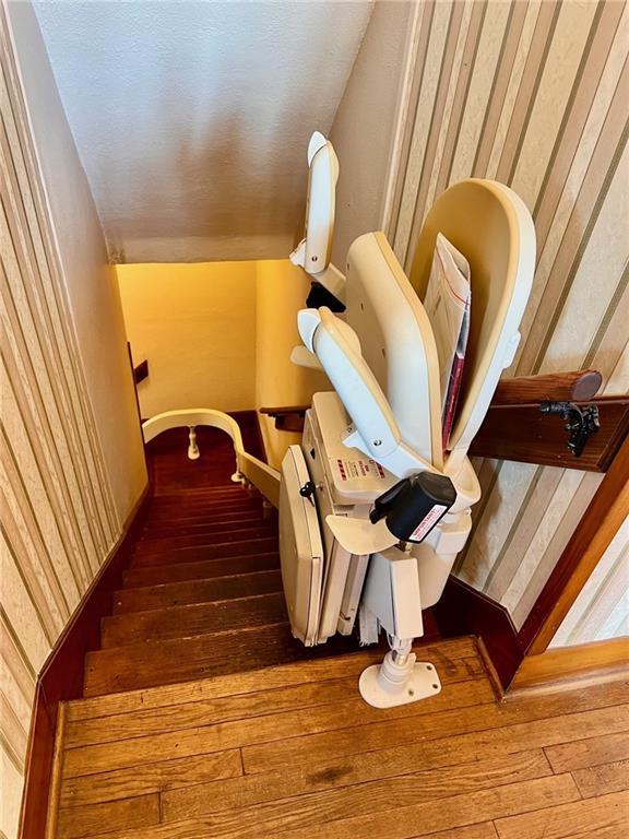 stairway with vaulted ceiling and wood finished floors