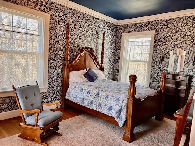 bedroom featuring wallpapered walls, baseboards, and wood finished floors