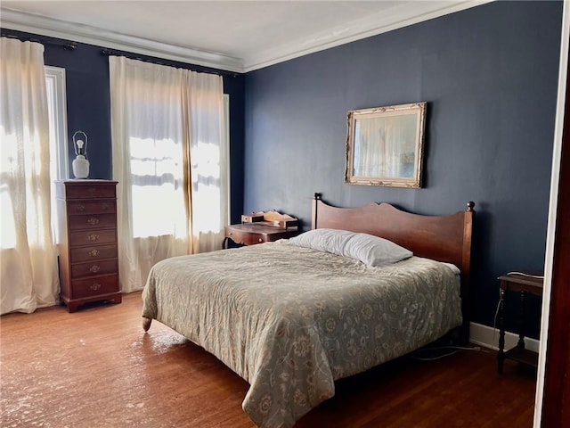 bedroom featuring wood finished floors and crown molding