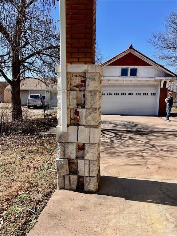 exterior details with concrete driveway and stone siding