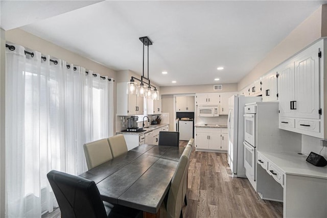 dining space with recessed lighting, visible vents, washing machine and clothes dryer, and wood finished floors