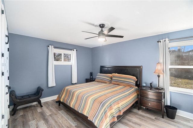 bedroom with a ceiling fan, baseboards, and wood finished floors