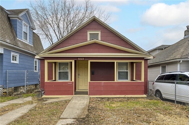 bungalow-style home featuring a porch and fence