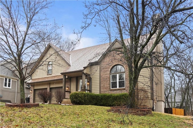 view of front of home featuring brick siding, an attached garage, a front lawn, and fence