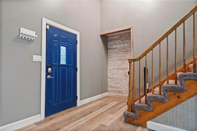 entrance foyer featuring stairway, wood finished floors, and baseboards