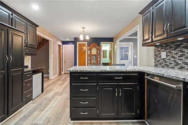 kitchen featuring dishwasher, a peninsula, light wood-type flooring, fridge, and backsplash