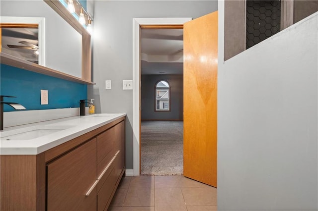 bathroom with ceiling fan, tile patterned flooring, a sink, and double vanity