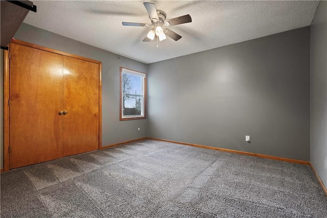 unfurnished bedroom featuring carpet floors, ceiling fan, baseboards, and a textured ceiling