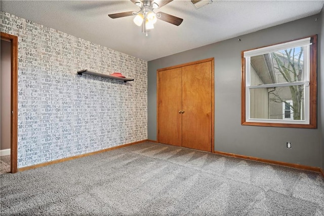 unfurnished bedroom with a textured ceiling, a closet, carpet, and baseboards