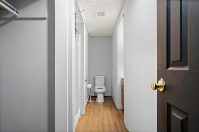 hallway with light wood-type flooring and baseboards