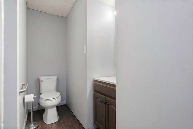 bathroom with wood finished floors, vanity, and toilet