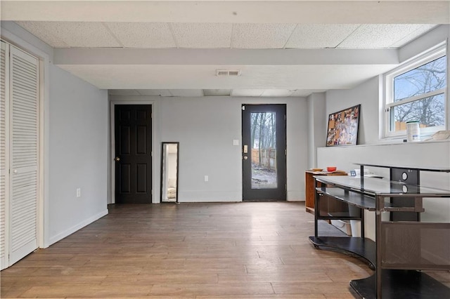 interior space featuring baseboards, visible vents, and wood finished floors