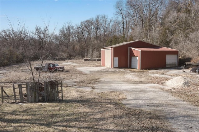 view of yard with an outbuilding, a garage, and dirt driveway
