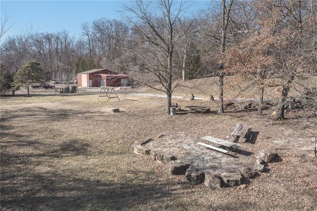 view of yard featuring a detached garage and an outbuilding