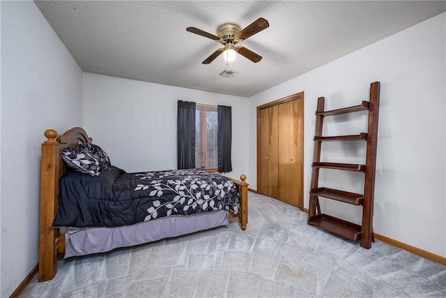 bedroom featuring baseboards, visible vents, carpet floors, and a textured ceiling