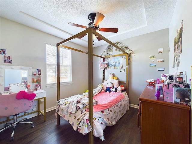 bedroom featuring a textured ceiling, dark wood finished floors, a ceiling fan, and baseboards