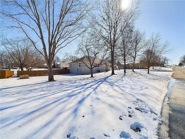 yard layered in snow featuring fence