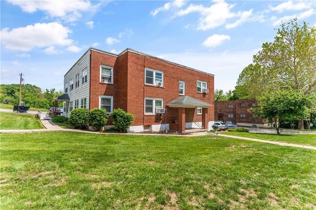 view of property with a front yard, brick siding, and cooling unit