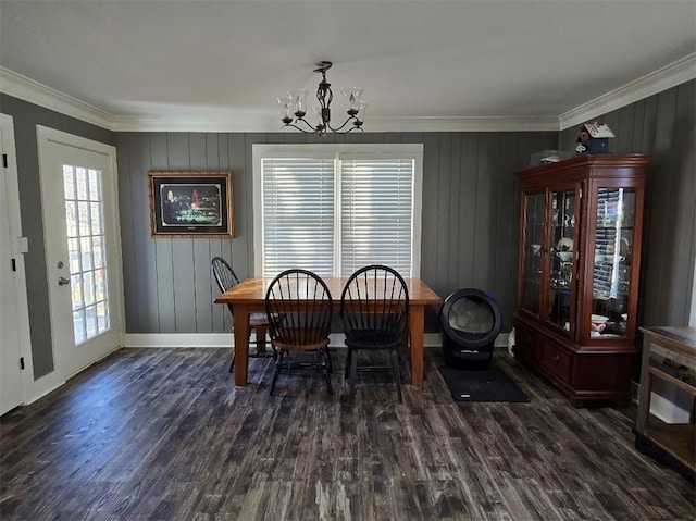 dining space featuring ornamental molding, baseboards, an inviting chandelier, and wood finished floors