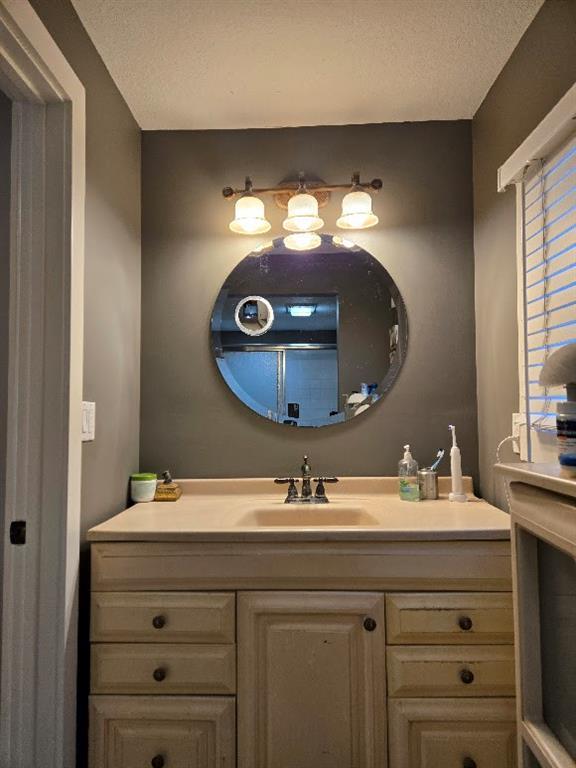 bathroom featuring a textured ceiling and vanity