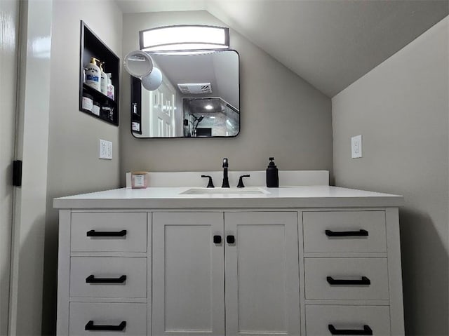 bathroom featuring vaulted ceiling and vanity