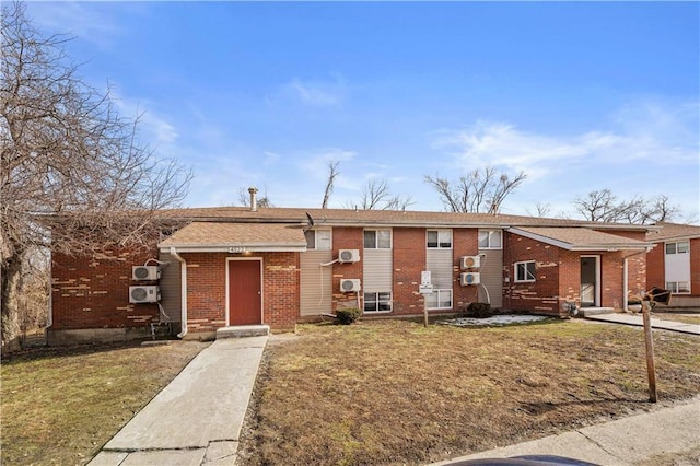 view of front of property with a front yard and brick siding