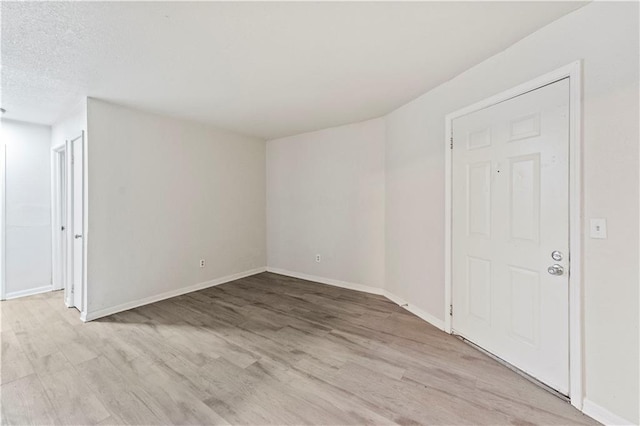 spare room featuring light wood-style flooring and baseboards