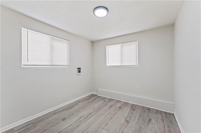 unfurnished room with light wood-style floors and baseboards