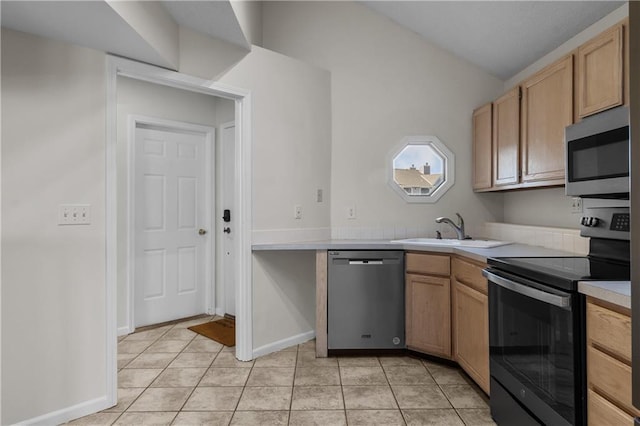 kitchen with light brown cabinetry, stainless steel appliances, a sink, and light countertops