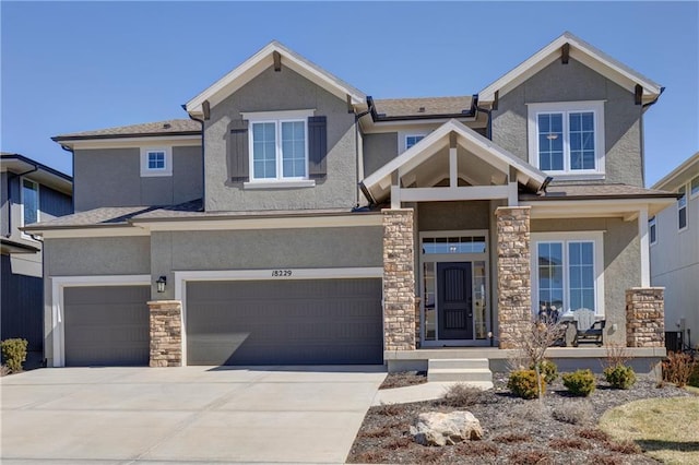 craftsman house with stucco siding, stone siding, and a garage