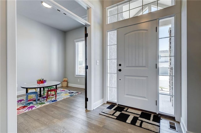 entrance foyer featuring visible vents, baseboards, and wood finished floors