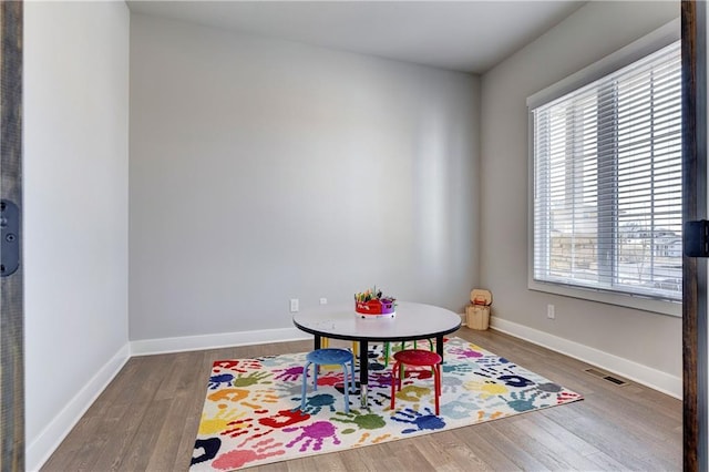 game room featuring wood finished floors, visible vents, and baseboards