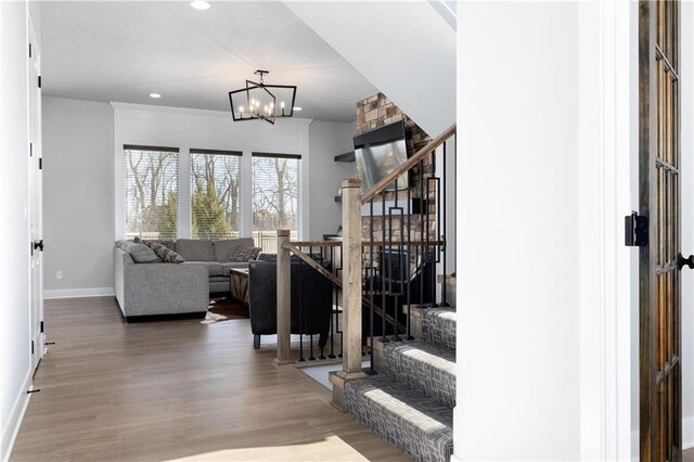 entryway with baseboards, stairway, recessed lighting, an inviting chandelier, and wood finished floors