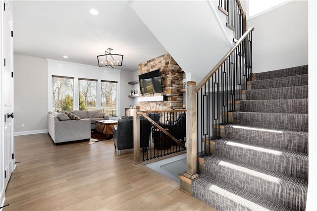 stairway with recessed lighting, baseboards, an inviting chandelier, and wood finished floors