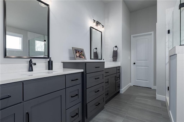 full bathroom featuring a sink, an enclosed shower, and two vanities