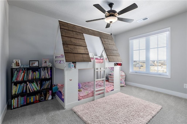 carpeted bedroom featuring a ceiling fan, baseboards, and a textured ceiling