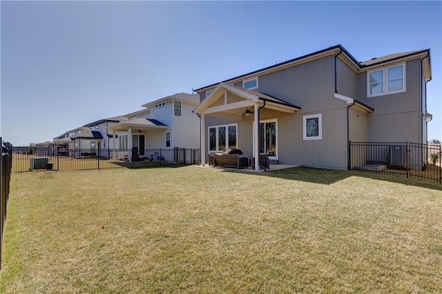 rear view of property with a lawn, a ceiling fan, and fence